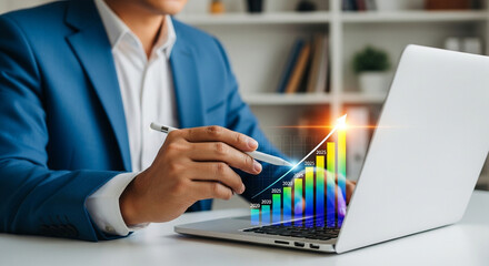 A businessman analyzes growth charts on a laptop screen