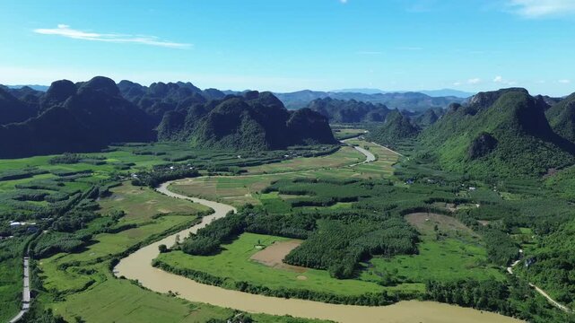 Pan right aerial movement showing wide river and karst mountains under bright daylight in Phong Nha, Vietnam