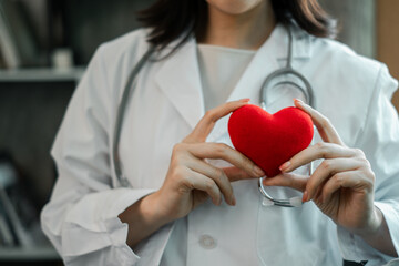 Close-up of a doctor holding a heart, representing healthcare and compassion in a medical...