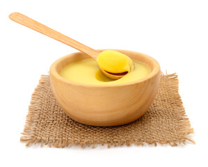 Ghee in a wooden bowl isolated.