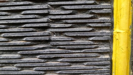 Dark textured wall with a contrasting yellow stripe. Great for backgrounds and abstract designs.