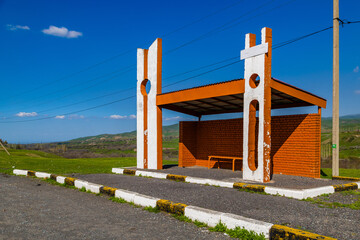 Orange and white bus shelter in peaceful rural Kyrgyzstan landscape