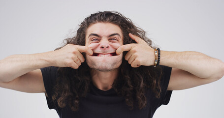 Portrait, goofy and man with funny face, studio or silly with facial expression or white...