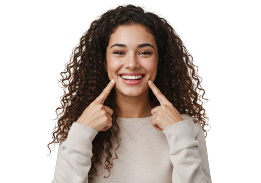 Young woman with curly hair smiling broadly and pointing to her cheeks, isolated on transparent background
