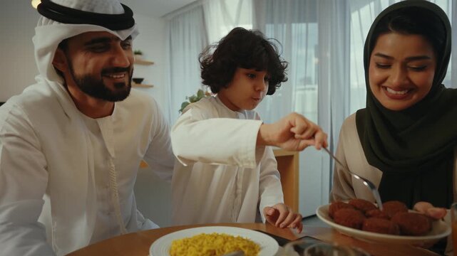 Multigenerational muslim family sharing warm meal together, sitting around dining table, enjoying traditional arabic cuisine with smiling interaction and familial connection