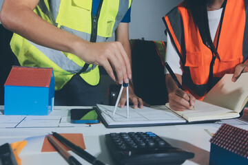 Closeup of team of industrial engineers meeting analyze machinery blueprints consult project on...