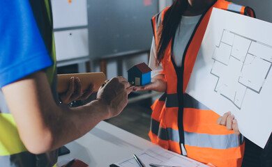 Closeup of team of industrial engineers meeting analyze machinery blueprints consult project on...