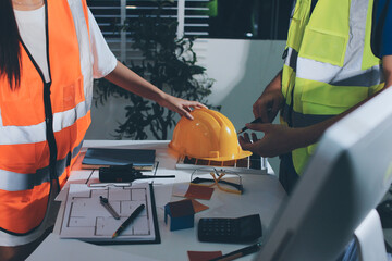 Closeup of team of industrial engineers meeting analyze machinery blueprints consult project on...