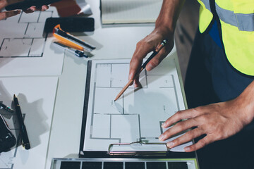 Closeup of team of industrial engineers meeting analyze machinery blueprints consult project on...