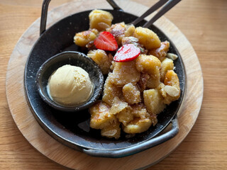 Traditional austrian bavarian dish kaiserschmarrn with ice cream and strawberry on iron pan  high angle view	
