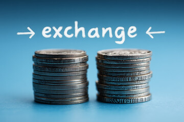 Coin Stacks with Exchange Text. Stacks of coins on blue background with 'exchange' text. Ideal for financial services and trading themes.