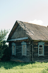 Obraz premium Rustic wooden house with blooming hydrangeas and a round wooden bench in the front yard