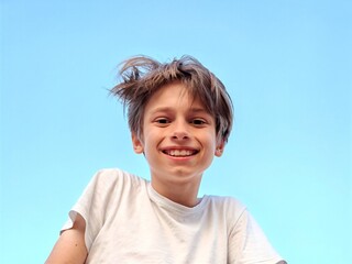 Closeup portrait of smiling school boy looking at camera. portrait of a happy Caucasian teenager boy against a blue sky