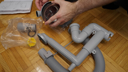 Plumber putting together new pieces of kitchen sink pipes
