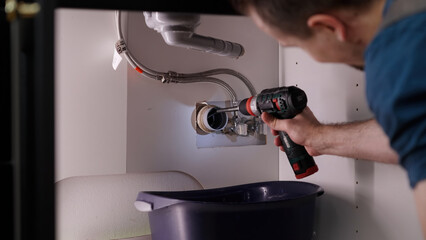 Plumber drill through clogged sink pipes with spring tube tool