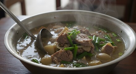Steaming Hot Delicious Beef Soup with Potatoes and Green Onions in a Large Metal Bowl