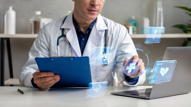 Doctor interacting with futuristic holographic medical interface displaying health icons and data on a laptop - Powered by Adobe