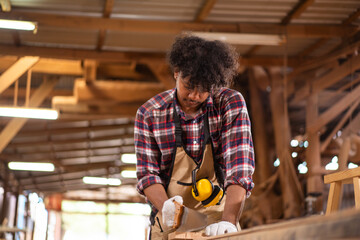 Professional African male carpenter is working professionally in sawmill - workshop.