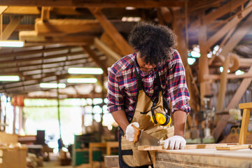 Professional African male carpenter is working professionally in sawmill - workshop.