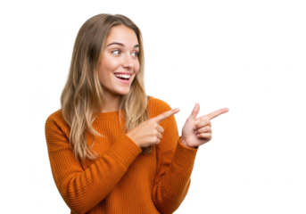 A happy young woman in an orange sweater points to the side with a big smile, isolated on a transparent background