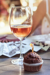 Adult birthday celebration with small chocolate cake with a burning candle and a glass of wine