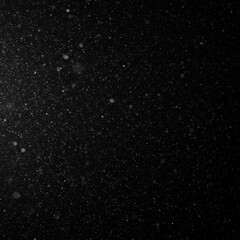 A monochrome image capturing a flurry of tiny, bright particles suspended against a vast, dark expanse