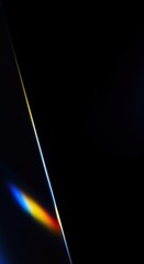 A sliver of light showcasing a rainbow spectrum against a deep black background, highlighting dispersion