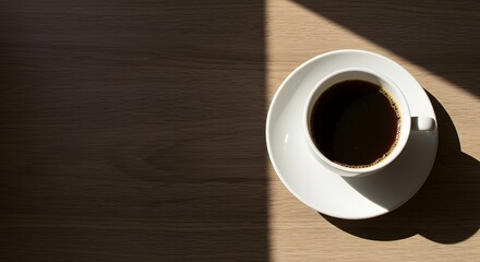 Close Up of a Cup of Black Coffee on a Wooden Table with Soft Shadows and Bright Light