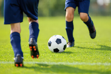 Obraz premium Youth Soccer Game Action Shot Featuring Players Dribbling the Ball on a Green Field, Capturing the Energy and Excitement of Sports