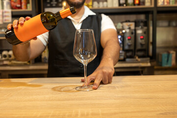 Bartender pouring wine into glass in restaurant bar