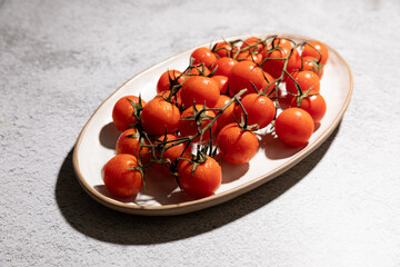 Fresh cherry tomatoes served on a dish with cast shadow