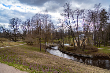 Kentaur Bridge over Slavyanka River in Pavlovsk Park. Neoclassical pavilion surrounded by bare...