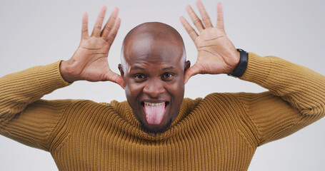 Funny face, portrait and tongue out with black man in studio for comic, meme or joke. Facial...