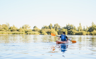 Kayaker paddling on calm lake enjoying water sports and recreation