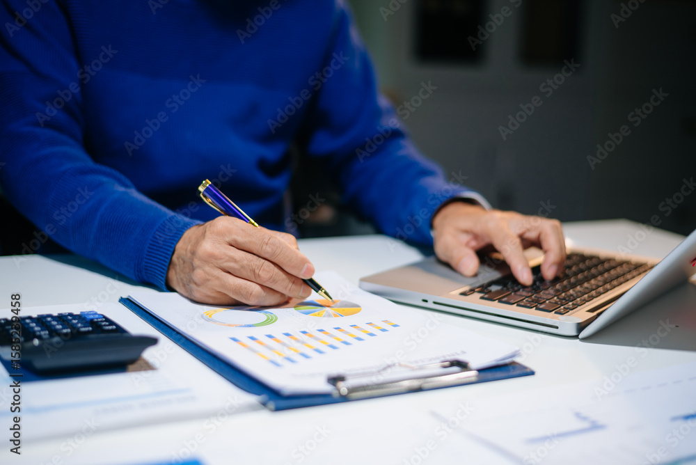 Poster bussinessman analyzing sales data and economic growth and pointing at business report document with 