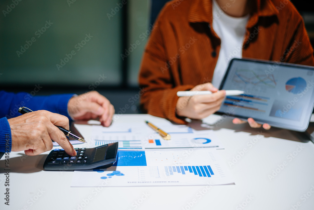 Poster businessman hand using laptop and tablet with social network diagram and two colleagues discussing d
