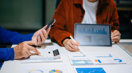 Businessman and team analyzing financial statement Finance task. with smart phone and laptop and ...