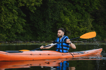 Kayaker paddling kayak on lake in summer day