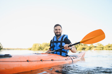 Kayaker paddling kayak on river in summer