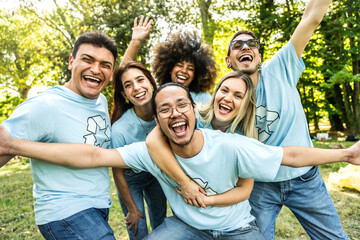 Multi ethnic group of volunteers cleaning up a forest together - Happy team of environmental...