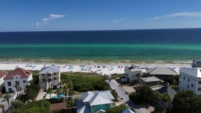 Forward drone movement at coastal beach meeting turquoise ocean bay, 30A, Florida, USA
