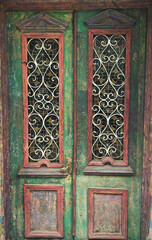Old wooden antique door decorated with glass inserts with stained glass windows