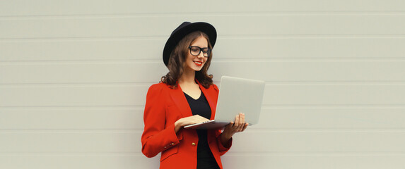 Happy modern young woman working on a laptop, freelancer girl with computer