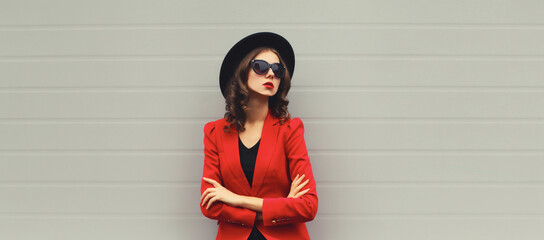 Stylish elegant confident young woman with crossed arms posing looking away
