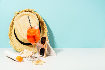 Summer alcohol cocktail drink and summer accessories at blue background. Aperol Spritz in wine...