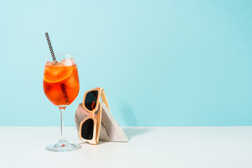 Summer alcohol cocktail drink at blue background. Aperol Spritz in wine glass,