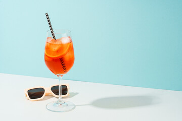 Summer alcohol cocktail drink at blue background. Aperol Spritz in wine glass,