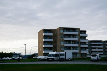 Residential apartment building with parked vehicles in rural Akranes, Iceland landscape