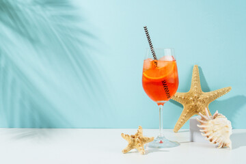Summer alcohol cocktail drink at blue background. Aperol Spritz in wine glass and sunglasses,...