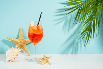 Summer alcohol cocktail drink at blue background. Aperol Spritz in wine glass,